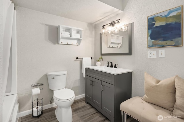 bathroom featuring wood finished floors, toilet, vanity, baseboards, and a shower with shower curtain