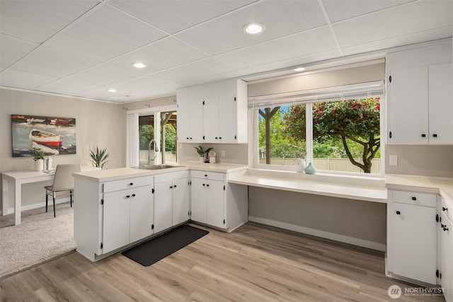 kitchen with a sink, light wood-style flooring, white cabinetry, and recessed lighting