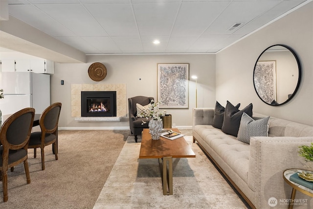 living room featuring carpet flooring, a tiled fireplace, recessed lighting, and baseboards