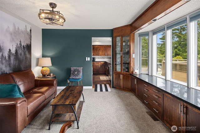 living area featuring carpet floors, a textured ceiling, and a chandelier