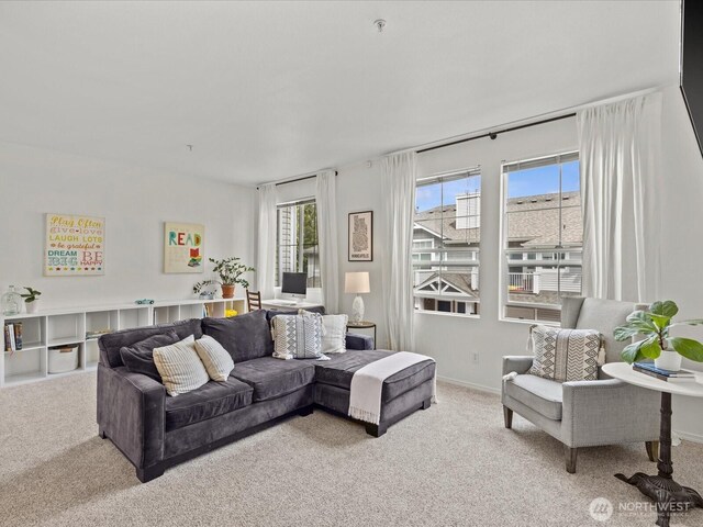 carpeted living area featuring baseboards