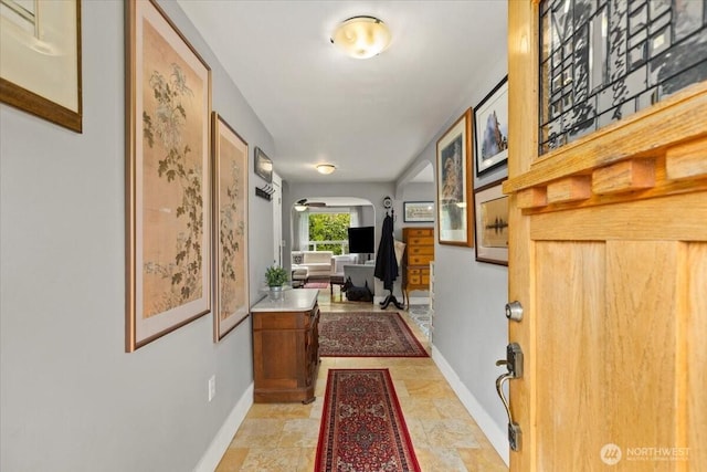 304 Riverview Dr NE, Auburn, WA 98002 - corridor featuring baseboards, arched walkways, and light stone finish floors