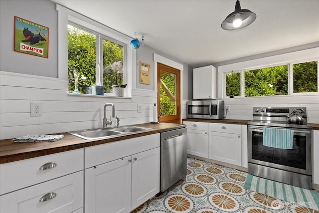 304 Riverview Dr NE, Auburn, WA 98002 - kitchen featuring appliances with stainless steel finishes, a sink, wooden counters, and plenty of natural light