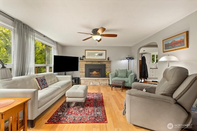 304 Riverview Dr NE, Auburn, WA 98002 - living area featuring a ceiling fan, arched walkways, light wood finished floors, and a fireplace