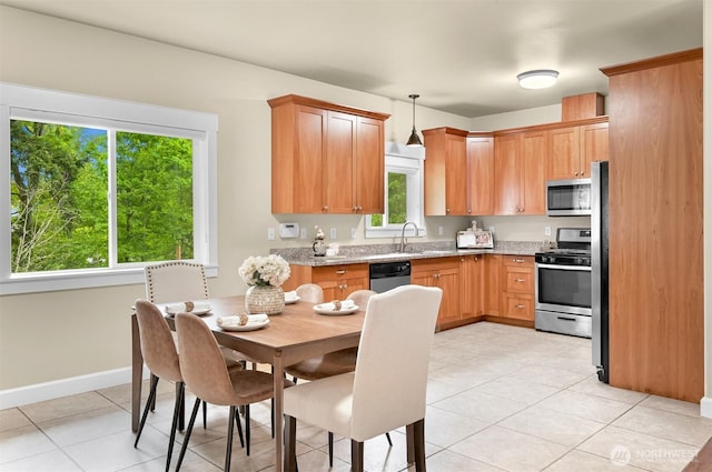 2225 Old Lakeway Dr, Bellingham, WA 98229 - kitchen featuring appliances with stainless steel finishes, light tile patterned floors, light stone countertops, a sink, and decorative light fixtures