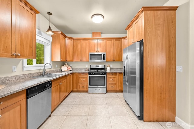 2225 Old Lakeway Dr, Bellingham, WA 98229 - kitchen with stainless steel appliances, a sink, light tile patterned flooring, hanging light fixtures, and brown cabinetry
