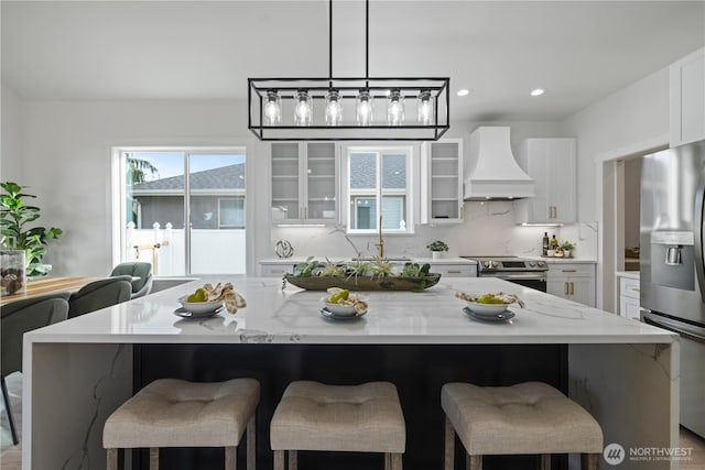 kitchen with custom range hood, stainless steel appliances, white cabinetry, a center island, and recessed lighting