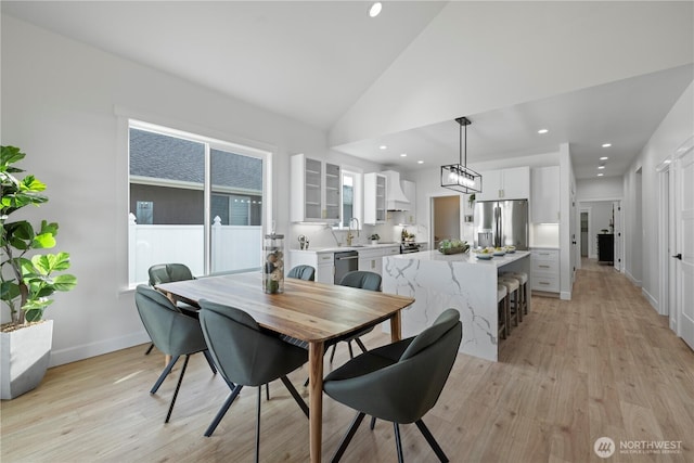 dining room with light wood-type flooring, lofted ceiling, baseboards, and recessed lighting