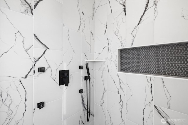 bathroom view of a marble finish shower