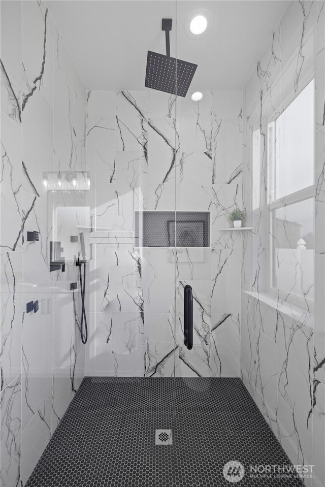 bathroom featuring a marble finish shower