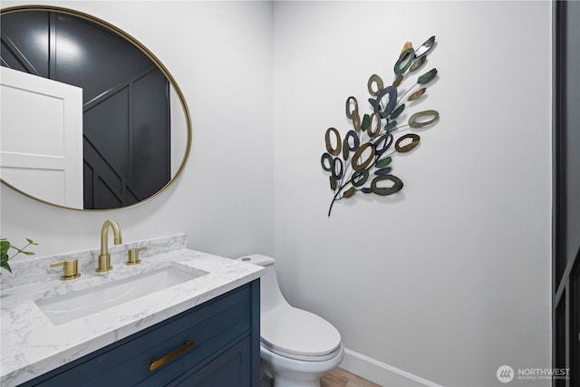 half bathroom featuring toilet and vanity