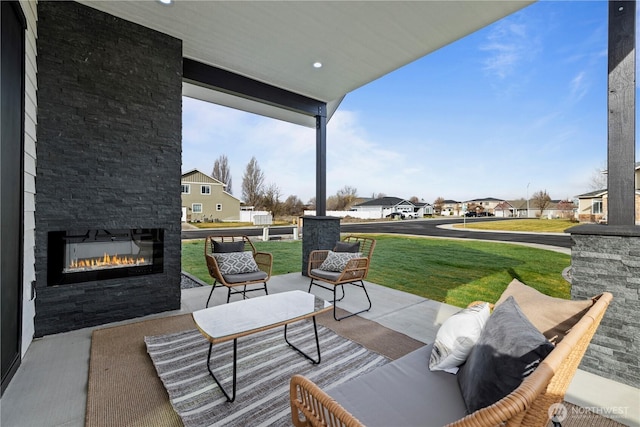 view of patio featuring an outdoor stone fireplace and a residential view