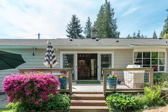 back of property featuring a deck and a chimney