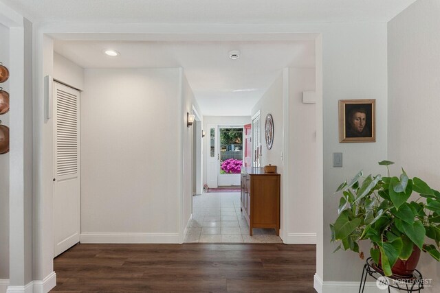 hall featuring wood finished floors, baseboards, and recessed lighting
