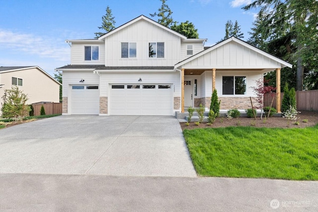 7332 284th St NW, Stanwood, WA 98292 - view of front of house with an attached garage, stone siding, and board and batten siding