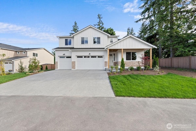 7332 284th St NW, Stanwood, WA 98292 - view of front of property with board and batten siding, an attached garage, stone siding, and concrete driveway