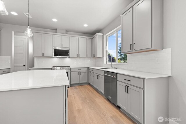 7332 284th St NW, Stanwood, WA 98292 - kitchen featuring appliances with stainless steel finishes, gray cabinets, light wood-style floors, tasteful backsplash, and recessed lighting
