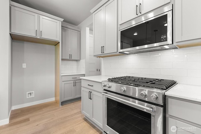 7332 284th St NW, Stanwood, WA 98292 - kitchen featuring appliances with stainless steel finishes, light wood-style flooring, and tasteful backsplash