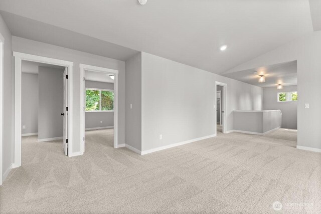 7332 284th St NW, Stanwood, WA 98292 - unfurnished living room featuring carpet flooring, vaulted ceiling, and healthy amount of natural light