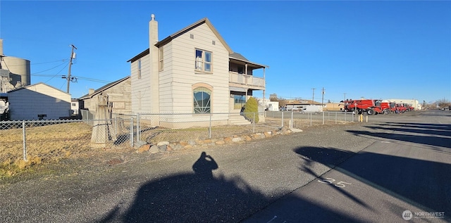 202 W 2nd Ave, Odessa, WA 99159 - view of front of property with fence, a chimney, and a balcony