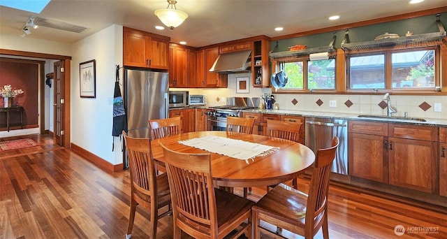 kitchen featuring a sink, appliances with stainless steel finishes, range hood, dark wood-style floors, and recessed lighting