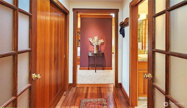 hall featuring wood finished floors and baseboards