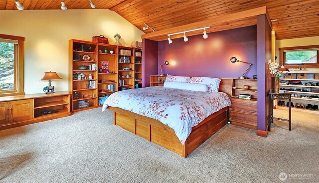 bedroom with rail lighting, wooden ceiling, carpet flooring, multiple windows, and vaulted ceiling