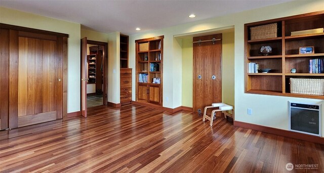 interior space with wood finished floors, built in features, baseboards, and recessed lighting