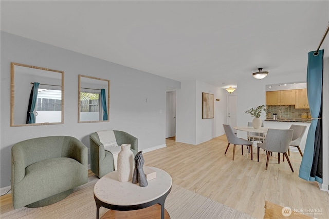 living area with light wood-type flooring and baseboards