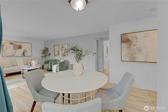 dining space featuring wood finished floors and baseboards