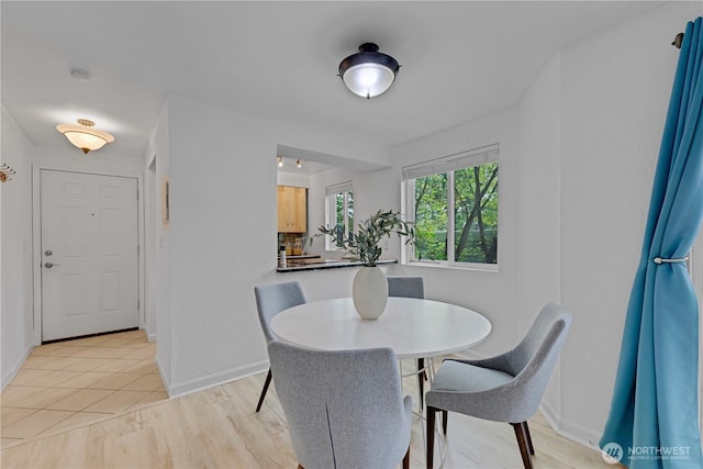 dining area featuring baseboards and light wood-type flooring