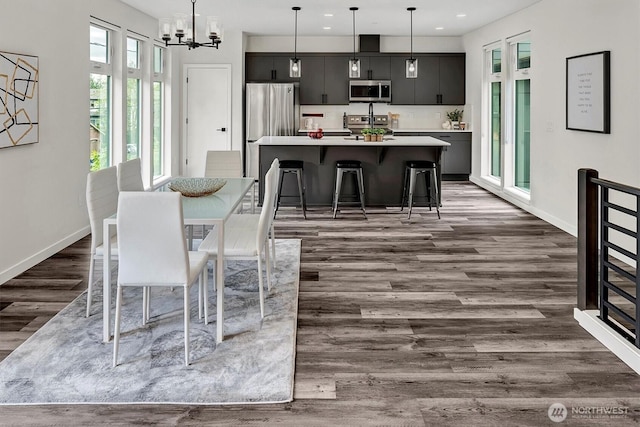 dining area with dark wood-style flooring, baseboards, a chandelier, and recessed lighting