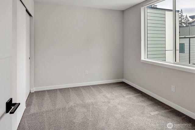 unfurnished bedroom featuring carpet, baseboards, and a closet
