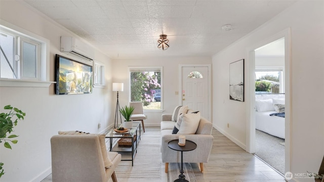 living room featuring light wood finished floors, a wall mounted AC, and baseboards