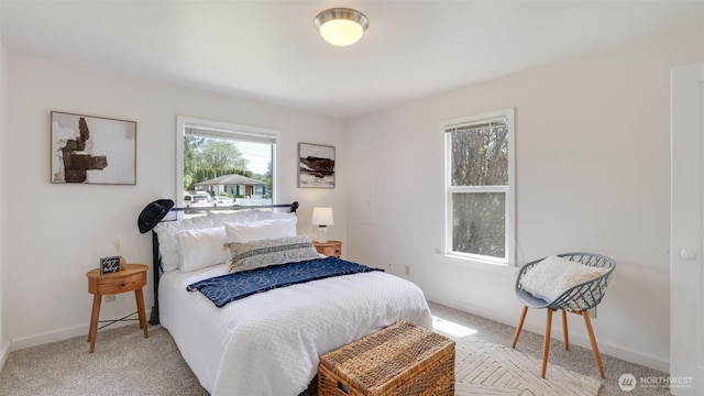 bedroom featuring light colored carpet and baseboards
