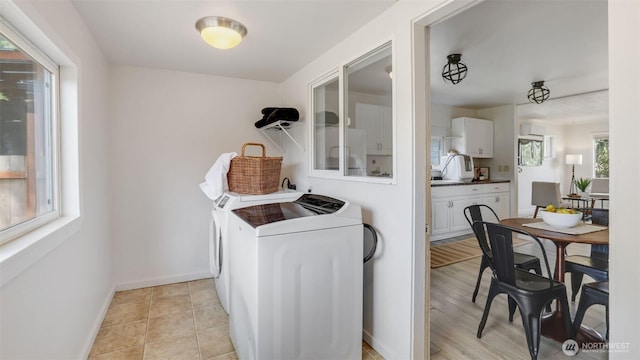 washroom with washer and clothes dryer and baseboards