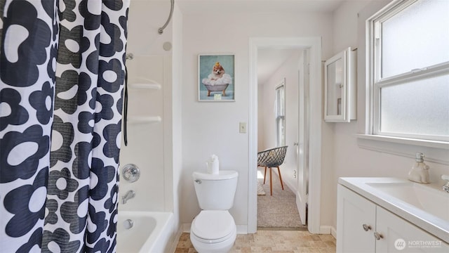 bathroom featuring toilet, vanity, shower / tub combo, and baseboards