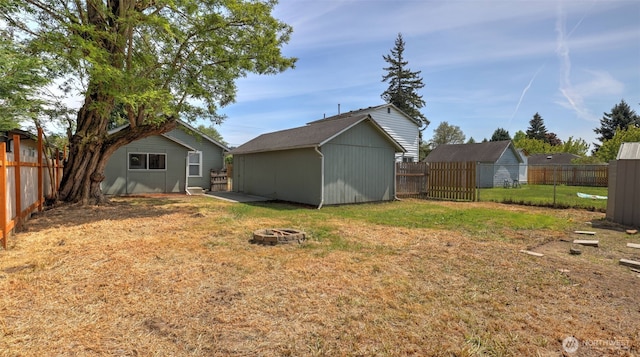 view of yard featuring an outdoor fire pit and an outbuilding