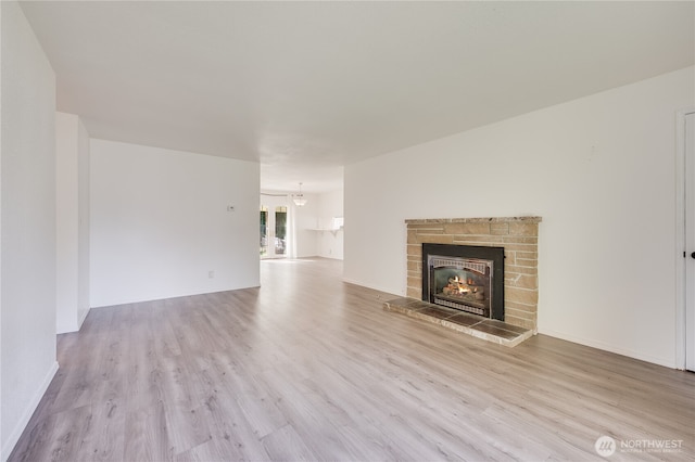 605 W Euclid Ave, Shelton, WA 98584 - unfurnished living room with wood finished floors, a brick fireplace, and baseboards