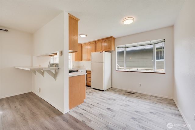 605 W Euclid Ave, Shelton, WA 98584 - kitchen featuring freestanding refrigerator, light wood finished floors, a peninsula, and light countertops