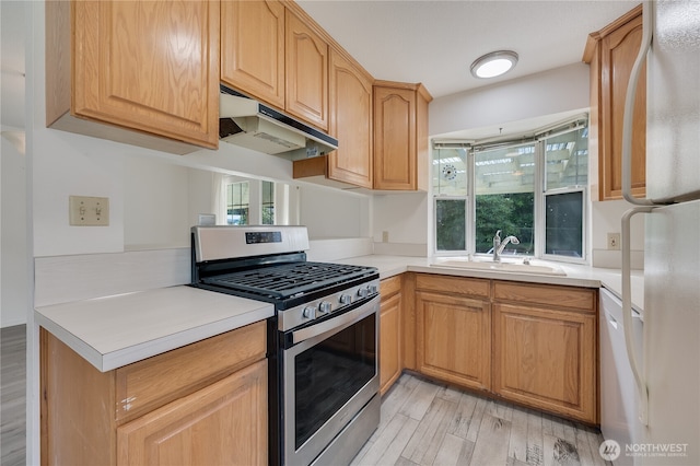 605 W Euclid Ave, Shelton, WA 98584 - kitchen featuring stainless steel range with gas stovetop, a sink, under cabinet range hood, freestanding refrigerator, and light countertops