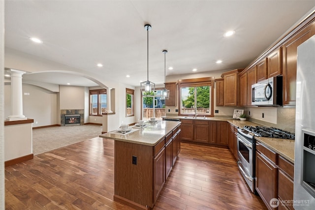 13809 172nd Pl E, Puyallup, WA 98374 - kitchen with appliances with stainless steel finishes, a sink, brown cabinetry, a center island, and dark wood-style floors