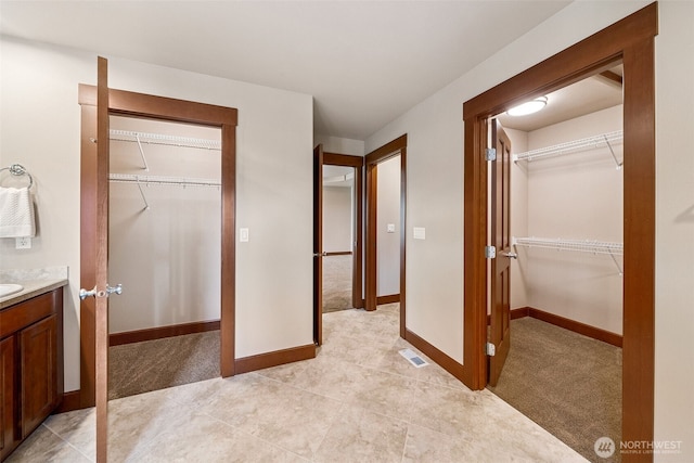 13809 172nd Pl E, Puyallup, WA 98374 - unfurnished bedroom featuring a spacious closet, a closet, light carpet, baseboards, and light tile patterned floors