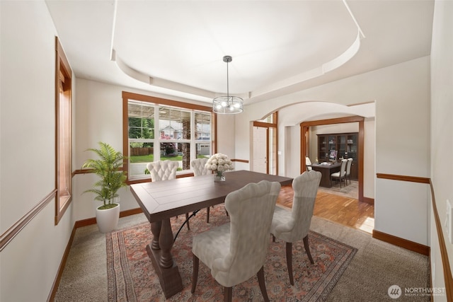 13809 172nd Pl E, Puyallup, WA 98374 - dining space with arched walkways, a chandelier, baseboards, light carpet, and a tray ceiling
