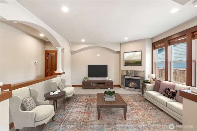 13809 172nd Pl E, Puyallup, WA 98374 - living room with recessed lighting, ornate columns, a tiled fireplace, arched walkways, and baseboards