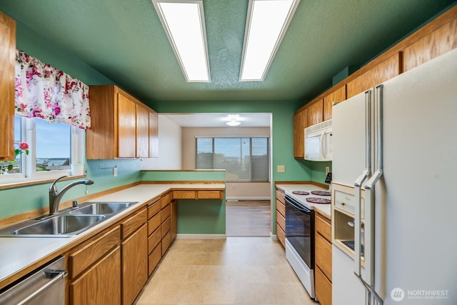 1068 Vista Del Monte, Camano Island, WA 98282 - kitchen with white appliances, a sink, a peninsula, light countertops, and a textured ceiling