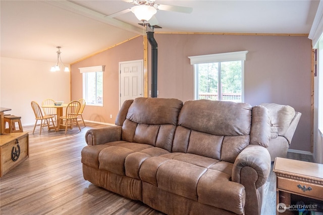 living area featuring wood finished floors, healthy amount of natural light, a ceiling fan, and lofted ceiling