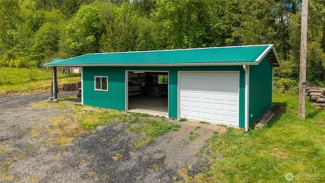 detached garage featuring a view of trees