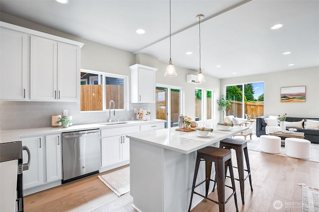 2900 NE 5th Pl, Renton, WA 98056 - kitchen featuring dishwasher, a sink, a breakfast bar, light countertops, and recessed lighting