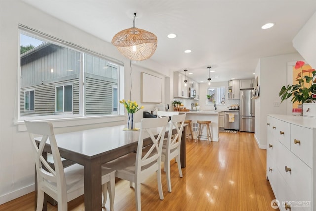 dining room with plenty of natural light, light wood finished floors, recessed lighting, and baseboards